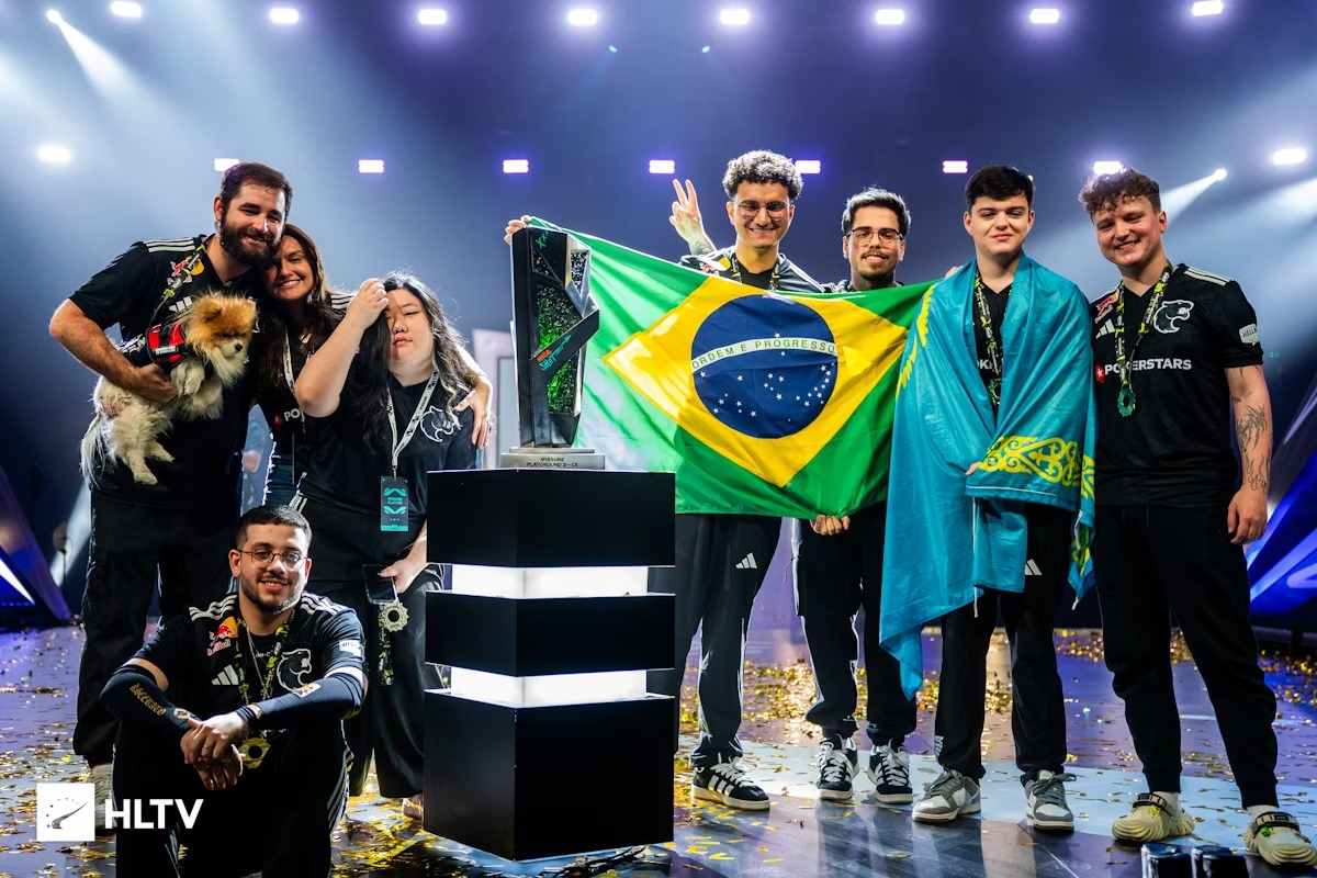 Time da FURIA comemorando título ao lado de um troféu com a bandeira do Brasil